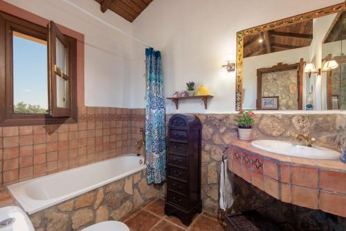 a bathroom with a tub and a sink and a tub and a mirror at Hacienda Los Olivos in Ronda