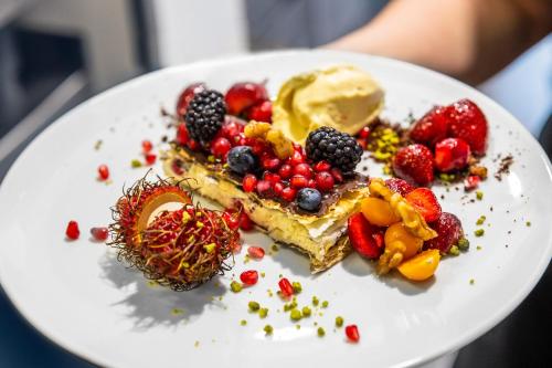 a plate of food with fruit and ice cream at Hotel Tannenhaus in Schöneck