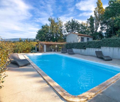 a swimming pool with chairs and a house at Villas de La Ferme Du Gros Noyer in Malaucène