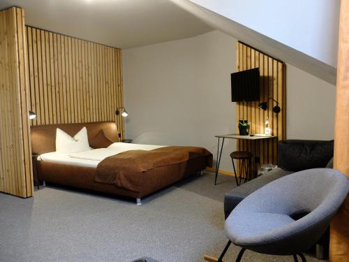 a hotel room with a bed and a chair at Hotel Postkeller in Krumbach