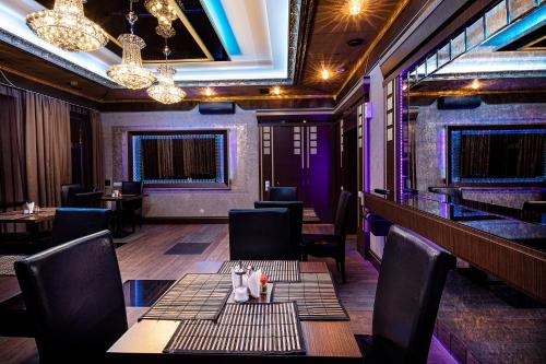 a restaurant with tables and chairs and purple walls at Biplan City in Daugavpils