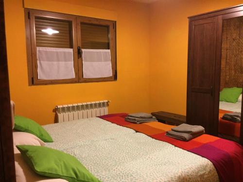a bedroom with a large bed with towels on it at El Mirador de la Sierra Y Casa Rosmari in Urueñas