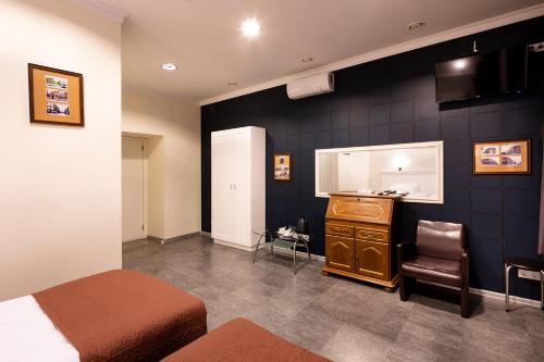 a bedroom with a bed and a dresser and a kitchen at Biplan City in Daugavpils
