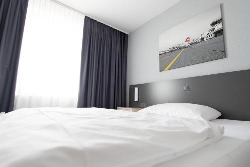 Ένα ή περισσότερα κρεβάτια σε δωμάτιο στο Airporthotel Grenchen