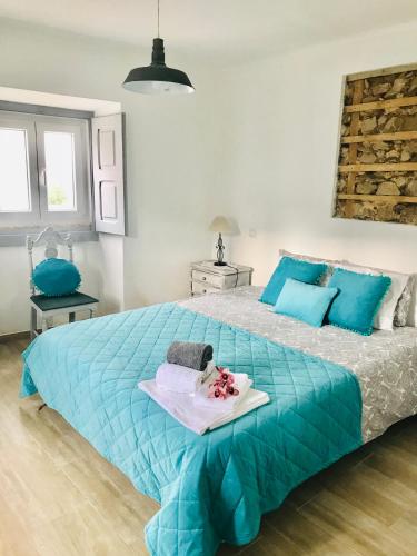 a bedroom with a blue bed with a tray on it at Casas do Patheo in Óbidos