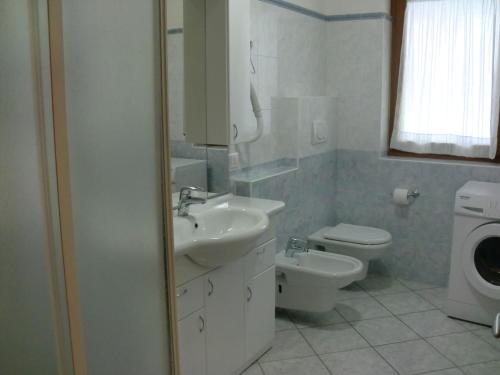 a white bathroom with a sink and a toilet at Agritur Planchenstainer in Riva del Garda