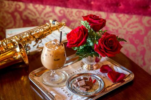 a tray with a drink and roses and a saxophone at Boutique Hotel Campo de' Fiori in Rome