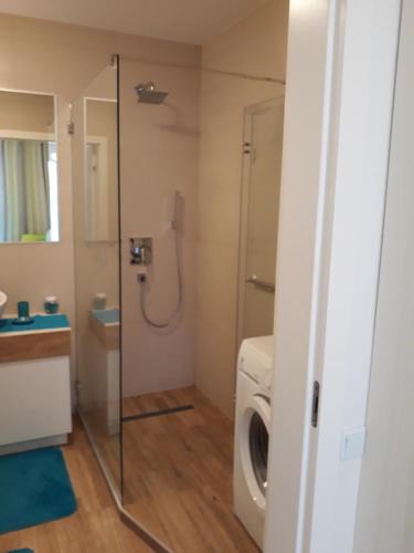 a bathroom with a washing machine and a washer at Horyzont-jantar314 in Międzyzdroje