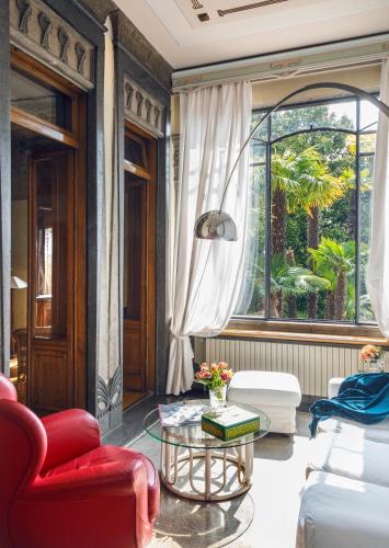 a living room with a red chair and a table at Hotel Laurin in Salò