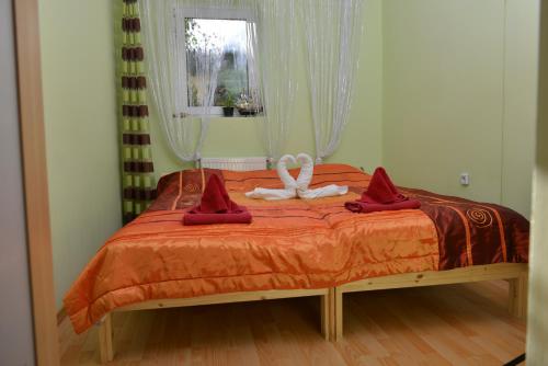 グディニャにある25 Jantarowaの赤いシーツと白い弓のベッド