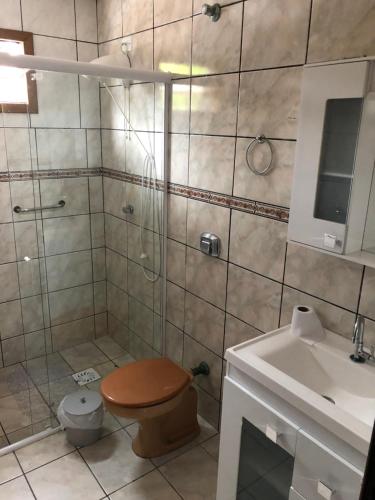 a bathroom with a shower and a toilet and a sink at Casas Verão Bombinhas in Bombinhas