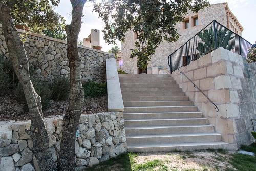 a set of stairs in front of a stone wall at Country House Sa Serra in Lloret de Vistalegre