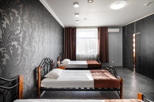 two beds in a room with a wall at Biplan Hotel in Daugavpils