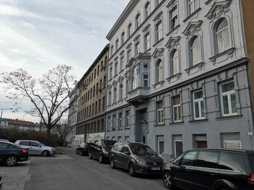 a row of cars parked on a street next to buildings at Ferienwohnung Diefenbachgasse in Vienna