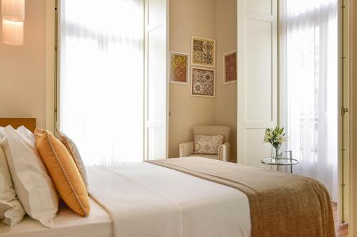 a bedroom with a large white bed with a window at My Story Hotel Ouro in Lisbon