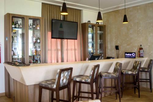 a bar with chairs and a flat screen tv at The Hill Hotéis Executive in São Carlos