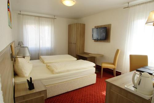 a hotel room with a bed and a television at Airport Hotel Filder Post in Stuttgart