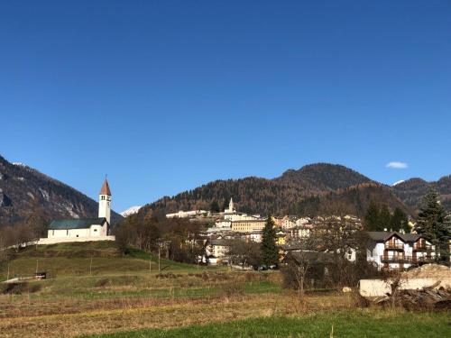 a small town on a hill with a church at Chalet Maso Pino in Castello Tesino