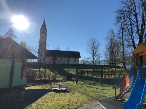 a playground with a clock tower in the background at Chalet Maso Pino in Castello Tesino
