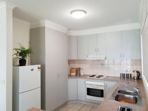Una cocina blanca con fregadero y refrigerador. en SAN Mateo, en Mildura