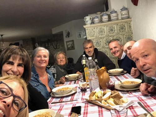 a group of people sitting at a table eating food at Chalet Maso Pino in Castello Tesino