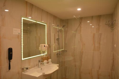 a bathroom with a sink and a shower with a mirror at Royal Grand Hotel and Spa - All Inclusive and Free beach accsess in Kavarna