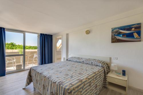 a bedroom with a bed and a balcony at Oltremare Appartamenti in Principina a Mare