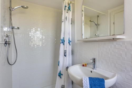 a white bathroom with a sink and a shower at Oltremare Appartamenti in Principina a Mare