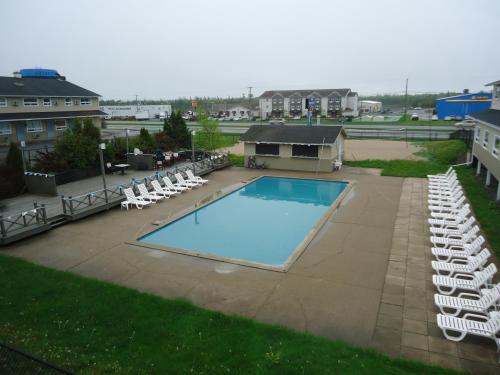 a swimming pool with lounge chairs and a swimming pool at Days Inn by Wyndham Fredericton in Fredericton