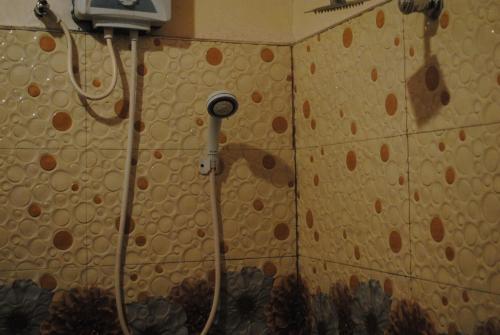 a shower in a bathroom with a tile wall at Singh Brothers in Adams Peak