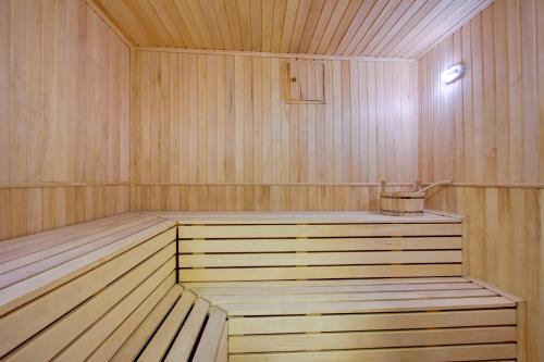 a wooden sauna with a tub with a pot in it at Karagat Hotel in Karakol