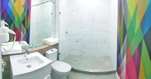 a bathroom with a toilet and a sink and a shower at Aсe Hotel in Aktobe
