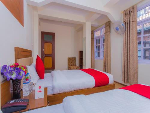 a hotel room with two beds with red and white at Durbar Home Stay in Pātan