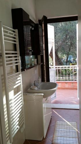 a bathroom with a white sink and a window at CASA OLEANDRO in Finale Ligure