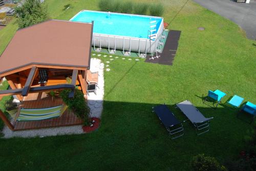 uma vista sobre um quintal com uma piscina e cadeiras em Gästehaus Luise em Waidring