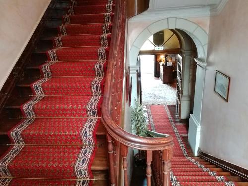 a staircase with red carpeting and a wooden railing at Alegre - Bussaco Boutique Hotel in Luso