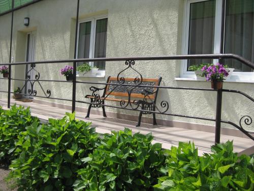 eine Bank auf einem Balkon mit Blumen in der Unterkunft Szalay Vendégház in Hegykő