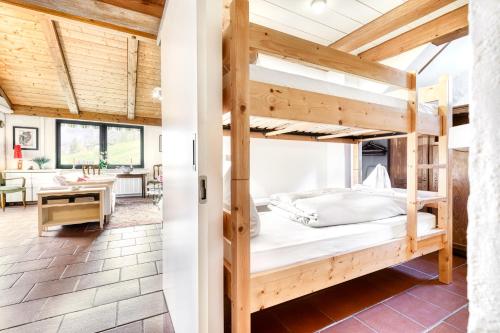 une chambre avec des lits superposés et une salle à manger dans l'établissement Chalet Zentral Bach by A-Appartments, à Brand