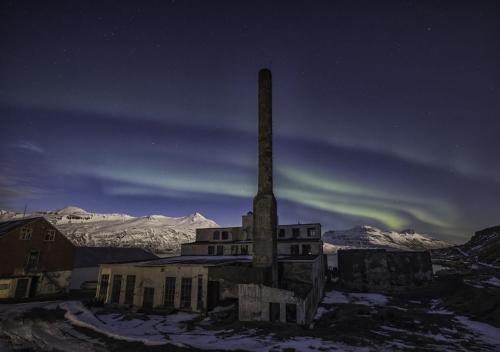 an old building with a tall tower in the snow at Hótel Djúpavík in Djupavik