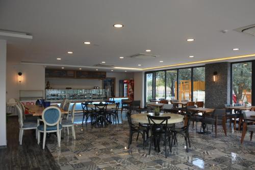 a dining room with tables and chairs and windows at Eleia Hotel İznik in Bursa