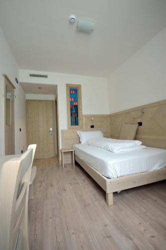 a bedroom with two beds and a table and chairs at Ai Vellutai in Ala