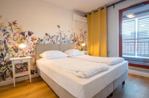 a bedroom with a bed with white sheets and a window at Grand Apartments - Apartments SPA Waterlane Island in Gdańsk