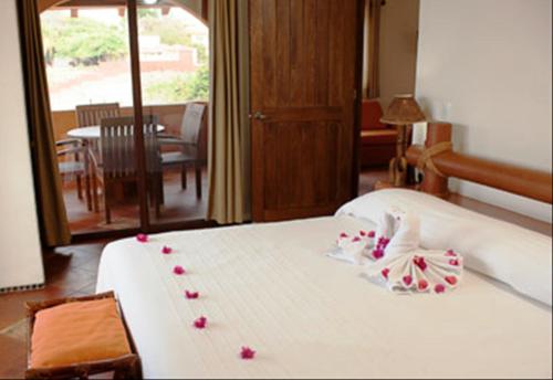 una habitación de hotel con una cama con flores. en Hotel la Quinta de Don Andres en Zihuatanejo