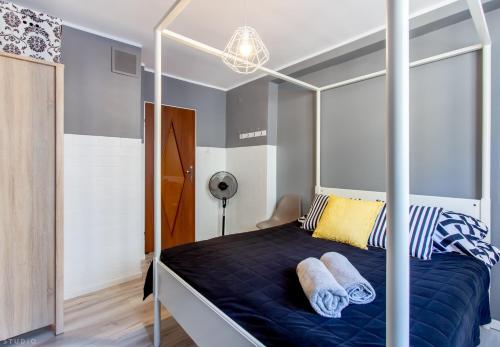 1 dormitorio con 1 cama con dosel y 2 almohadas en ClickTheFlat Constitution Square Apart Rooms, en Varsovia