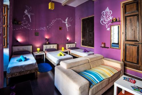 a purple room with two beds and a couch at Five Trees in Sliema