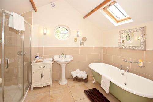 uma casa de banho com uma banheira, um lavatório e um chuveiro em Bellfry at Old Boley em Wexford