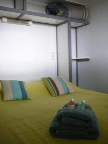 a bedroom with a bed with yellow sheets and pillows at Les Chalets des Mousquetaires in Mirepoix