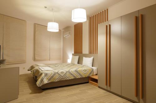 a bedroom with a bed and two pendant lights at Hotel Frigopan in Plovdiv