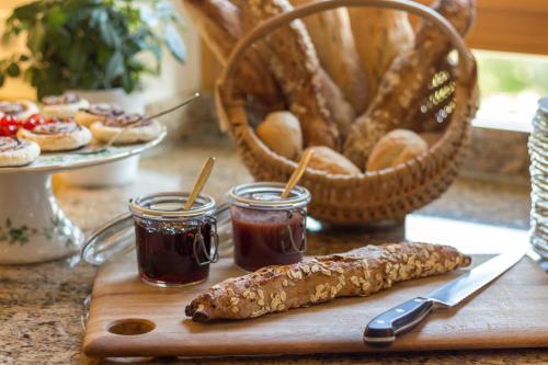 a wooden cutting board with two jars of jam and a bagel at Gästehaus Burgblick in Bisingen
