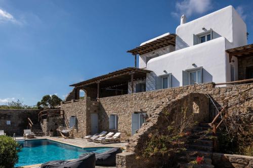 a villa with a swimming pool and a house at Summer Mood Villas (6 bedroom villa) in Mikonos